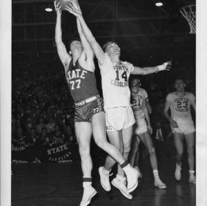 North Carolina State College basketball player Sam Ranzino (77) leaps for basketball during game against North Carolina.