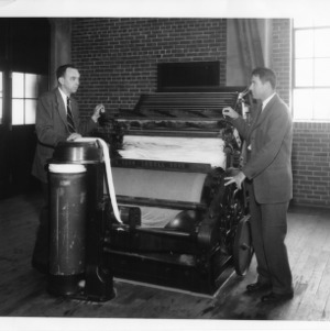 Professor Elliot B. Grover and George H. Dunlap at a cotton card in the School of Textiles