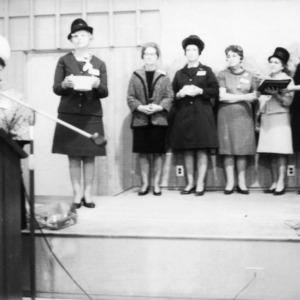 Group of women standing on stage behind podium