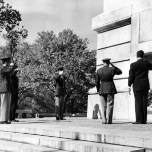 John W. Harrelson saluting at memorial