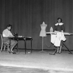 Two women demonstrating tasks on a stage