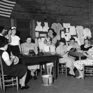 Group of women preparing a display on clothing or hats
