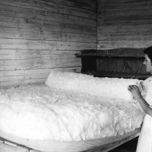 Woman making mattress with cotton bedding