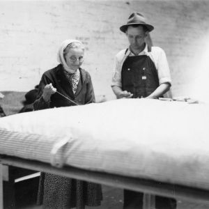 Woman and man sewing a mattress