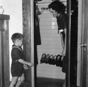 Woman and small boy looking into a children's closet