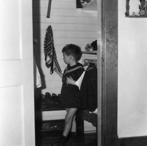 Small boy standing in a children's closet