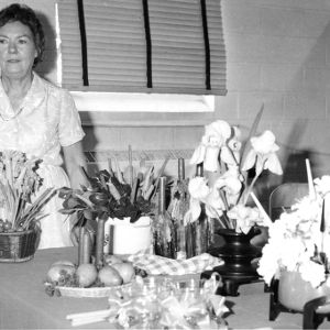Ann Williamson, Columbus County club chairman, with flower arrangements.