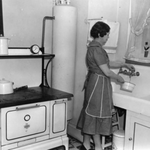 Mrs. E. L. Minor of Guilford County, the first winner of the county kitchen contest 1937-1938, standing in front of her sink