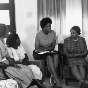 Home economics extension worker talking to African American mothers and children, May 24, 1967