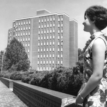 Woman in front of Carroll Residence Hall, the new woman's dorm