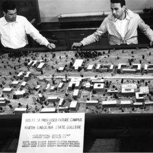 Two School of Design students posing with model of proposed future campus of North Carolina State College.