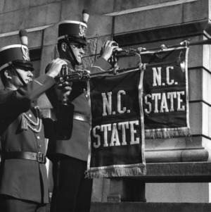 Two North Carolina State College marching band members playing trumpets at Memorial Bell Tower.