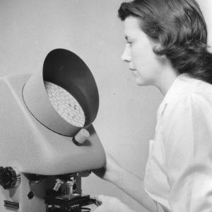 Woman using a Projectina projection microscope for research in the microscopy laboratory in the Textile Research Center at North Carolina State College.
