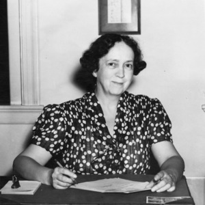 Miss Nora Lillington King at desk