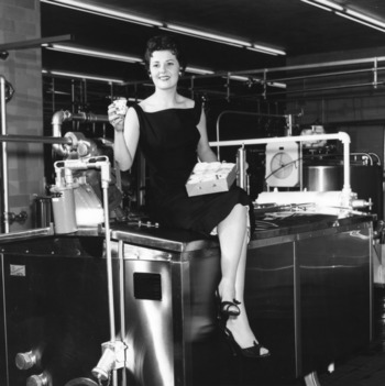 The Dairy Princess for 1958 posing with carton of ice cream in dairy factory for "June is Dairy Month" campaign.