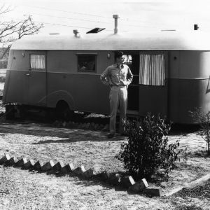 Man standing in front of trailer, Trailwood, North Carolina State College, March 1946.