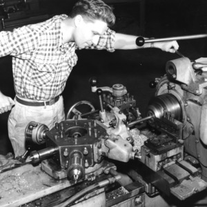Student with turrent lathe in Industrial Engineering department laboratory.