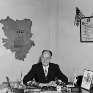 L. R. Harrill sitting at his desk