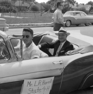 L. R. Harrill riding in the backseat of a convertible in a parade