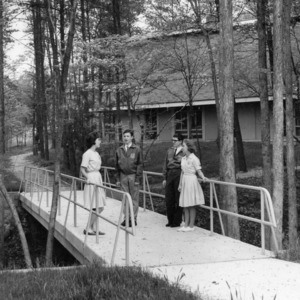 Four 4-H club members standing on a bridge at the Betsy-Jeff Penn 4-H Educational Center