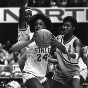 N.C. State's #24 Karen Brabson about to pass under heavy guard from two Carolina players