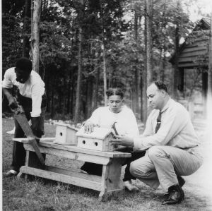 Wake County - July 14-17, 1941, Camp Whispering Pines. John Redding, Granville Co. agent, right, instructs four boys in use of hammer and saw while making bird houses at Wildlife conference