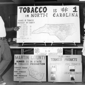 Two 4-H club members demonstrating the importance of tobacco to the state of North Carolina