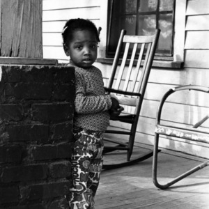Young African American girl standing on her front porch