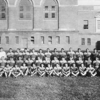 North Carolina State College football team posing behind Thompson Gymnasium.