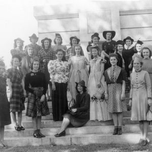 4-H club members wearing their entries in the 4-H Dress Revue standing in front of the bell tower at North Carolina State College in Raleigh