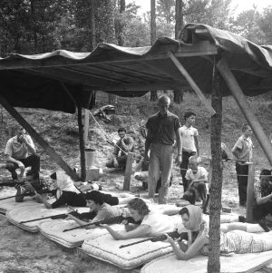 Young men and women receiving instruction in firearm safety and marksmanship on rifle range, 4-H Wildlife Camp, 1959