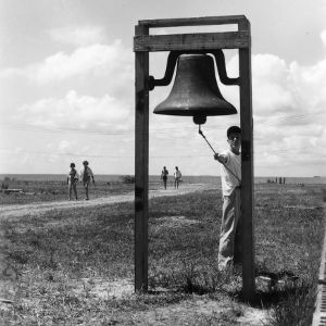 Boy ringing bell at Manteo, North Carolina, 4-H Camp