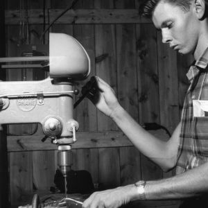 4-H club member using drill press in model farm shop at Millstone 4-H Camp