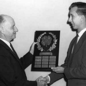 L. R. Harrill awarding a plaque to Glenn Woodley in 1957