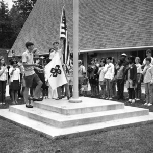 Four 4-H members raising the American flag and the 4-H flag at the Betsy-Jeff Penn 4-H Educational Center