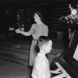 Woman singing and a boy playing the piano at a 4-H club in Vance County