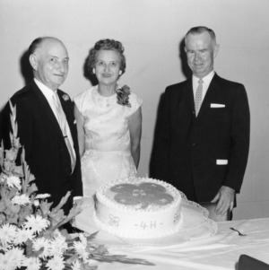 L. R. Harrill and two others holding a cake at the Honor Dinner