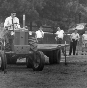 Young man driving tractor between posts during North Carolina State 4-H Club Week