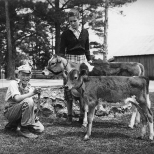Kenneth and Lucille Myatt in Wake County, North Carolina, holding their calves