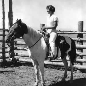 North Carolina State 4-H Club girl sitting on horse in corral