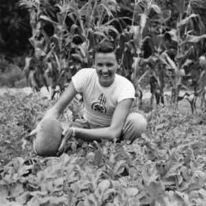 Unidentified 4-H club member displaying his squash at the Tew family farm