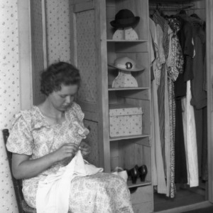 Hazel Sherrill of Iredell County, North Carolina, sitting in her project for a 4-H room improvement program. She made the closet from packing cases