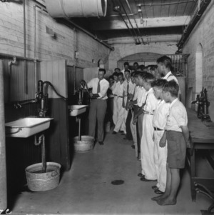 Instructor teaching a group of boys about plumbing at North Carolina State 4-H Short Course, 1932