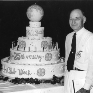L. R. Harrill standing in front of a 25th anniversary cake at North Carolina State 4-H Club Week