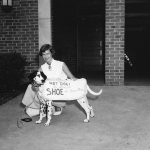 Woman with a dalmatian dog, wearing sign "Hot Dog! I'm voting for Shoe for Secretary!"