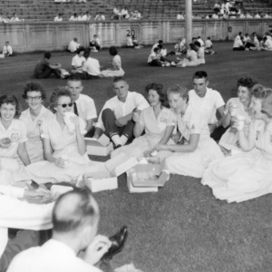 4-H club members picnicking on football field during North Carolina State 4-H Club Week