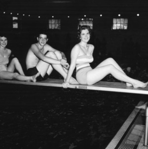 Two young women and a young man in swimsuits posing on a diving board during North Carolina State 4-H Club Week