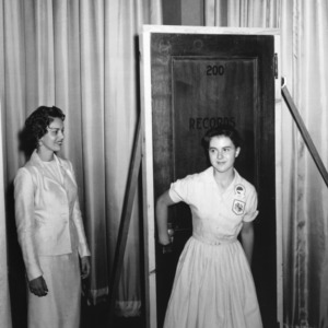 4-H club girl and woman rehearsing entry through a false door onstage, during North Carolina State 4-H Club Week