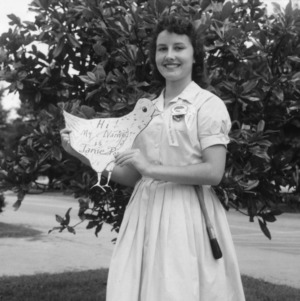 Club girl holding her bird-shaped initiation name tag, during North Carolina State 4-H Club Week