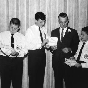 Three 4-H club boys and older man holding awards during North Carolina State 4-H Club Week